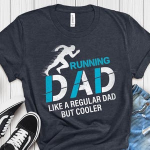 Könnte beinhalten: Heather-Marineblaues T-Shirt mit einer laufenden Figur und dem Text "Running Dad Like a Regular Dad But Cooler".