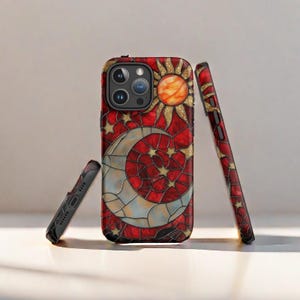 May include: A red, gold, and white phone case with a stained glass design of a crescent moon, sun, and stars. The case is designed for an iPhone.