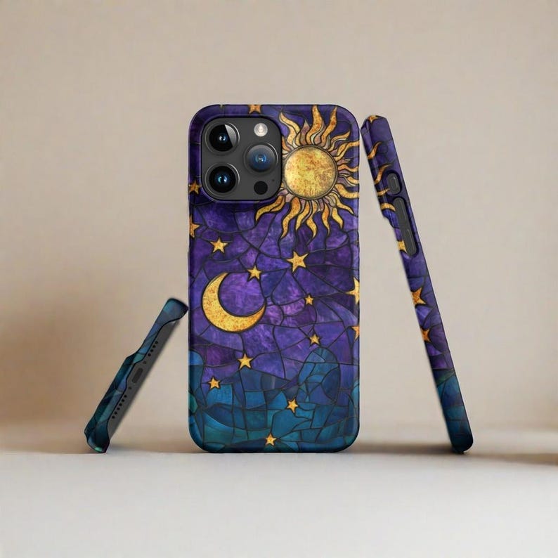 May include: A purple, blue, and gold phone case with a stained glass design of a sun, moon, and stars.