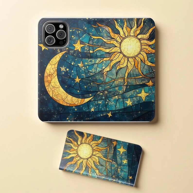 Op de afbeelding: Een telefoonhoesje en een telefoonhouder met een hemels ontwerp. Het ontwerp bevat een gouden zon, maan en sterren op een donkerblauwe achtergrond. De hoes heeft een camera-uitsparing en de houder is rechthoekig.