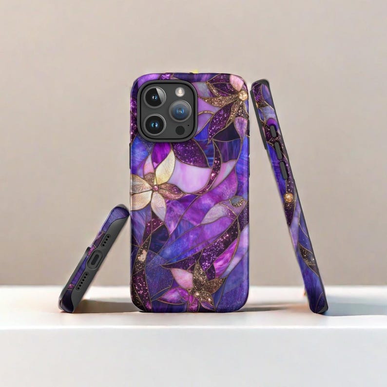 Op de afbeelding: Paarse en gouden telefoonhoes met een glas-in-loodontwerp met bloemen. De hoes wordt vanuit verschillende hoeken getoond.