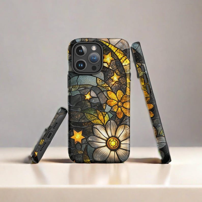 Op de afbeelding: Een zwarte telefoonhoes met een glas-in-loodontwerp met gele bloemen, sterren en een halve maan.