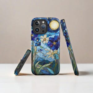 Op de afbeelding: Een blauwe en witte telefoonhoes met een glas-in-loodontwerp van bloemen en een maan. De hoes is ontworpen voor een iPhone.