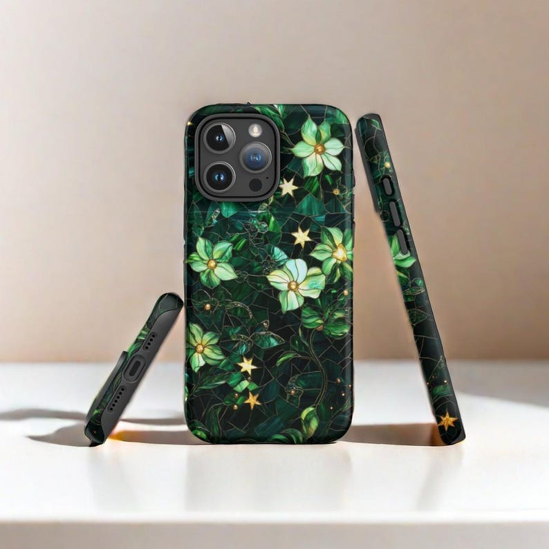 Op de afbeelding: Een zwarte telefoonhoes met een groen bloemenontwerp en gouden accenten. De hoes heeft een verhoogde camerabult en een transparante achterkant.