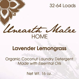 以下が含まれることがあります： 茶色のラベルに白い文字で、ブラウンのフォントで「Unearth Malee HOME」という洗濯洗剤製品が書かれています。製品は「ラベンダーレモングラス」オーガニックココナッツ洗濯洗剤で、エッセンシャルオイルを使用しています。ラベルには「32-64 回分」と「正味重量 16 オンス」と記載されています。