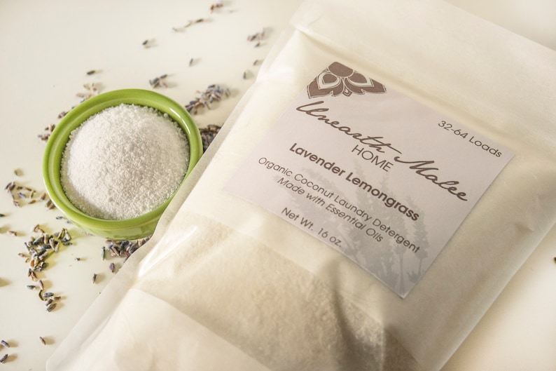 以下が含まれることがあります： 「Unearth Malee HOME Lavender Lemongrass Organic Coconut Laundry Detergent Made with Essential Oils Net Wt. 16 oz. 32-64 Loads」と書いてあるラベルが付いた白い袋。袋の中には白い粉が入っています。