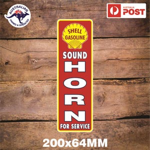 Puede incluir: Un letrero rojo y blanco con el texto "SOUND HORN FOR SERVICE" y un logotipo amarillo de Shell Gasoline. El letrero mide 200 mm por 64 mm.