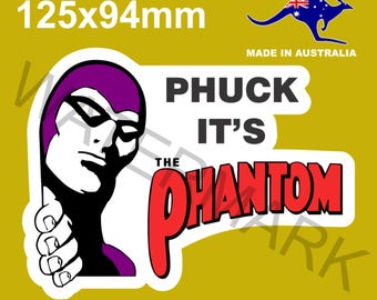 Peut inclure: Autocollant avec l'image de The Phantom, un personnage de bande dessinée, avec un masque violet et des gants blancs. Le texte dit "PHUCK IT'S THE PHANTOM". L'autocollant mesure 12,5 cm x 9,4 cm et est fabriqué en Australie.