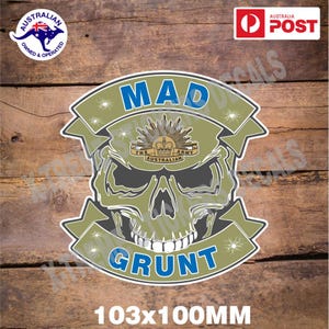 May include: A green and grey skull sticker with the words "MAD GRUNT" in blue lettering. The skull has a crown and the words "The Australian Army" on its forehead. The sticker is 103mm x 100mm.