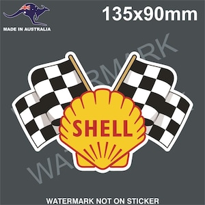 May include: A yellow and red Shell logo with the word "SHELL" in red letters. The logo is surrounded by two black and white checkered flags. The image is 135mm by 90mm.