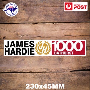 May include: White sticker with black text "JAMES HARDIE" and a gold wreath with the letters "JH" inside. The sticker also has a red rectangle with white text "1000 BATHURST". The sticker is 230x45 mm.