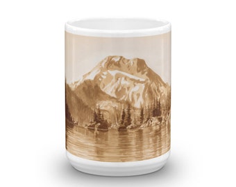 May include: A white ceramic coffee mug with a brown illustration of a mountain range and a lake. The illustration is in a sepia tone.