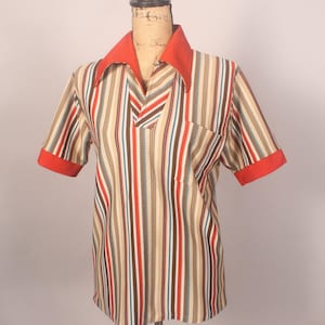 Könnte beinhalten: Ein gestreiftes Kurzarmhemd mit rotem Kragen und Manschetten. Das Hemd hat eine Tasche auf der linken Seite.