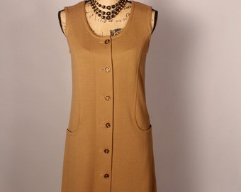 May include: A sleeveless, brown, button-front dress with pockets. The dress is on a mannequin wearing a black beaded necklace.