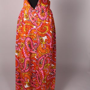 May include: A long, high-waisted skirt with a paisley print in shades of orange, pink, yellow, and white. The skirt has a button-up front and a fitted waistband.