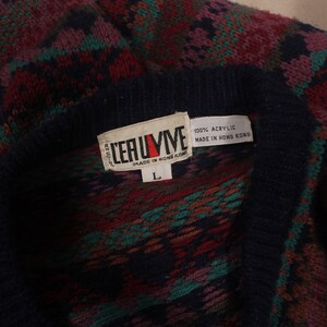 Puede incluir: Un su&eacute;ter de punto con estampado azul, rojo, verde y marr&oacute;n con una etiqueta blanca que dice "LERUIME" y "100% ACRYLIC MADE IN HONG KONG". La etiqueta tambi&eacute;n tiene una etiqueta de talla "L".