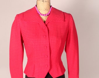May include: A pink, fitted blazer with a button-up front and long sleeves. The blazer is made of a textured fabric and has a slightly flared hem.