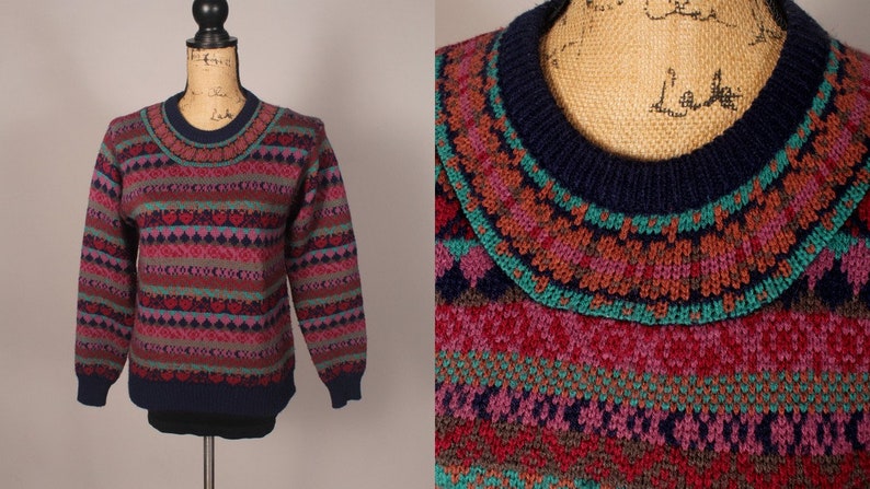 Puede incluir: Un su&eacute;ter azul marino con un patr&oacute;n geom&eacute;trico colorido. El patr&oacute;n incluye tonos de rosa, rojo, verde, marr&oacute;n y gris. El su&eacute;ter tiene cuello redondo.