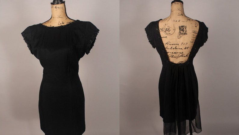 May include: A black sleeveless dress with a lace trim on the neckline and sleeves. The dress has a low back with a sheer panel.
