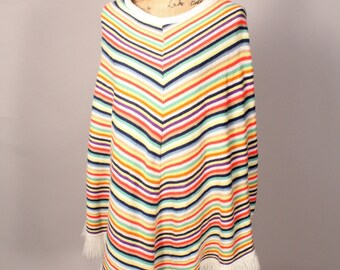 May include: A colorful striped poncho with a white fringe. The poncho is made of a soft, knitted fabric and has a relaxed fit.