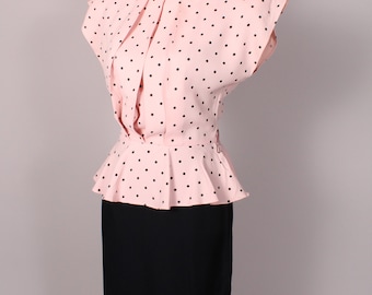 Puede incluir: Un vestido de lunares rosa y negro con falda ajustada y top peplum. El vestido tiene un escote redondo y mangas cortas.
