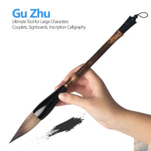 May include: A calligraphy brush with a textured brown bamboo handle, a black ferrule, and a pointed brown bristle tip. The text Gu Zhu Ultimate Tool for Large Characters Couplets, Signboards, Inscription Calligraphy is printed in the upper left corner.