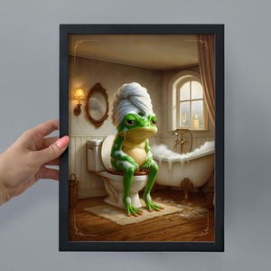 May include: Framed art print showing a green frog with a white towel on its head, sitting on a toilet. The frog looks unhappy. The bathroom setting includes a bathtub, mirror, and window, creating a humorous scene.
