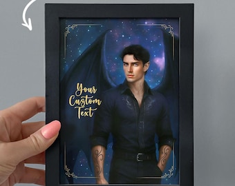 May include: A framed print featuring a man with dark hair, pointed ears, and large black wings against a starry night sky. The frame is black, and the print includes the text "Add Custom Text" and "Your Custom Text" in gold.