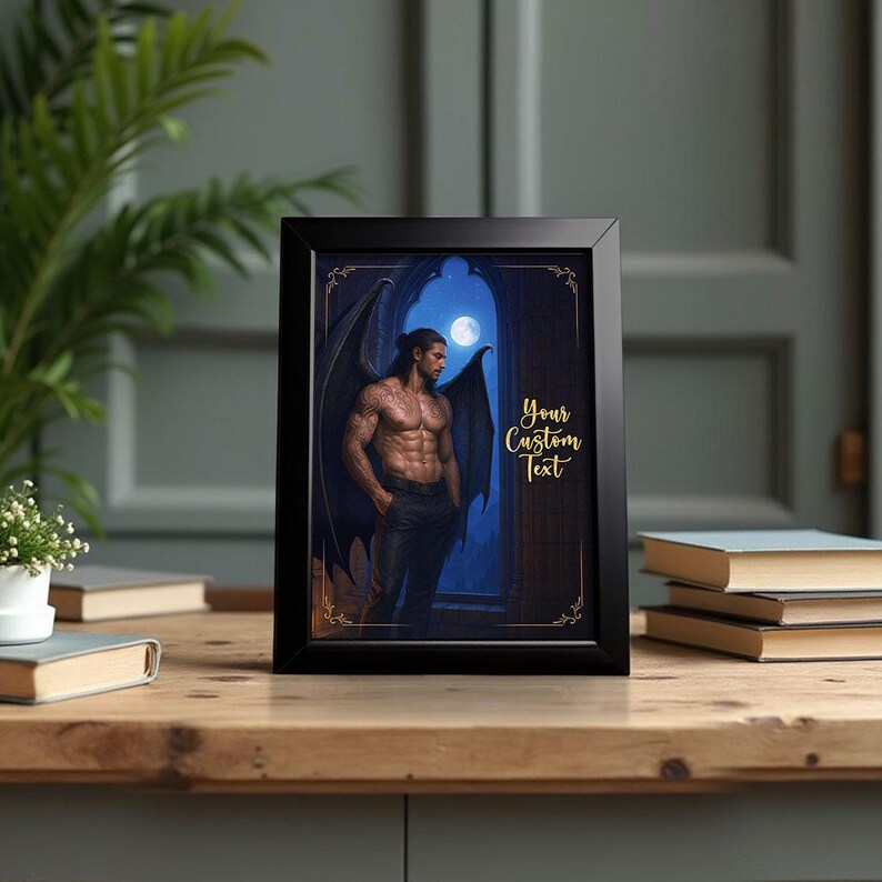 May include: Black framed art print featuring a muscular man with dark wings, standing in a gothic archway under a full moon. The print includes the text "Your Custom Text" in gold script.