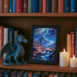 Puede incluir: Una impresi&oacute;n art&iacute;stica enmarcada con una escena de paisaje de fantas&iacute;a que presenta una cordillera, un r&iacute;o y una ciudad por la noche. Una figura de drag&oacute;n azul y dos velas encendidas est&aacute;n en una estanter&iacute;a de madera con libros.