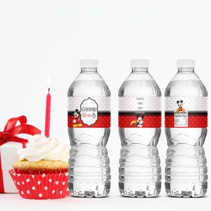 May include: Three clear water bottles with custom labels featuring Mickey Mouse designs. The labels have a red and white polka dot pattern, with text that reads "Jayden turns 4" and "Birthday". A cupcake with a lit candle and a wrapped gift are also in the image.