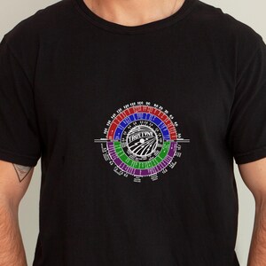 May include: Black t-shirt with a white graphic of a circular chart with the text "Tru-Time" in the center. The chart is divided into sections with different colors and numbers.