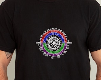 May include: Black t-shirt with a white graphic of a circular chart with the text "Tru-Time" in the center. The chart is divided into sections with different colors and numbers.