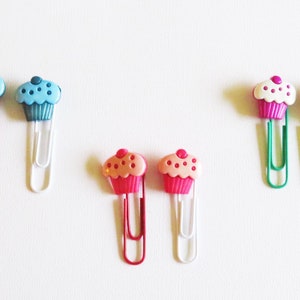 3 sets of paper clips decorated with cupcakes.     Choices include blue, pink, or white cupcakes on different color paper clips.   Use as bookmarks or planner clips.