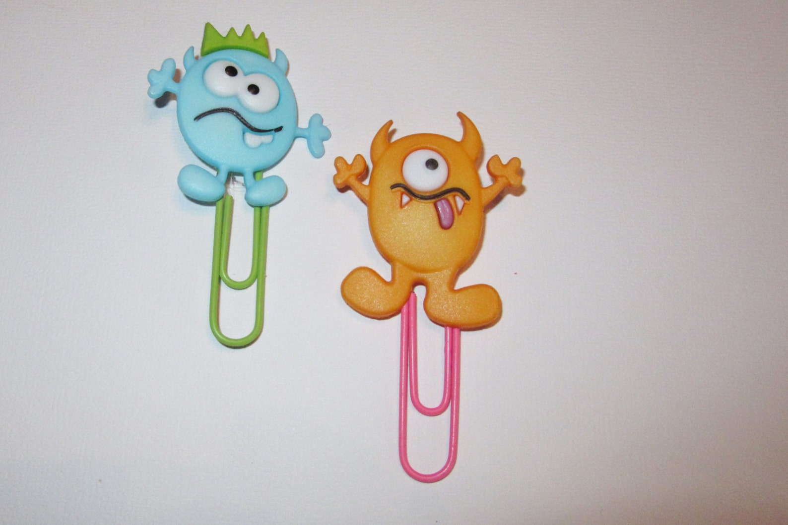 Two paperclip monster bookmarks against a white background. 