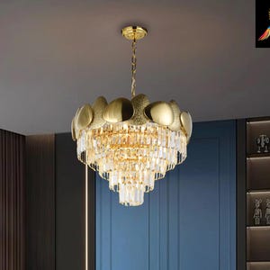 A brand-new, medium-sized round 5 tiered, contemporary chandelier with a leaf crystal and golden finish