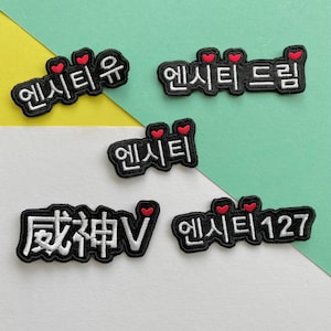 May include: Five embroidered patches with the Korean word "NCT" and different variations of the word. The patches are black with white lettering and red hearts.