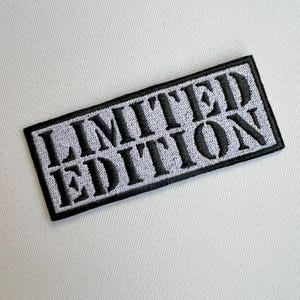 Peut inclure: Un patch brodé noir et gris avec le texte "LIMITED EDITION" en blanc.