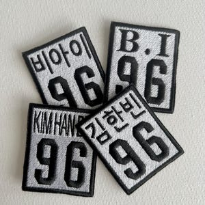 May include: Four black and white embroidered patches with the number 96 and different text. The patches include the text "B.I", "KIM HAN BIN", and Korean text.