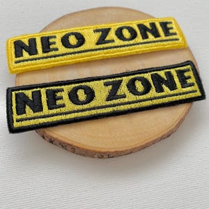 May include: Two black and yellow embroidered patches with the text "NEO ZONE" in black.