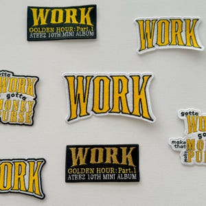 Puede incluir: Nueve parches bordados con la palabra "WORK" en letras amarillas sobre fondo negro. Algunos parches tienen texto adicional, incluyendo "gotta make that money purse" y "Golden Hour: Part 1 ATEEZ 10th Mini Album".