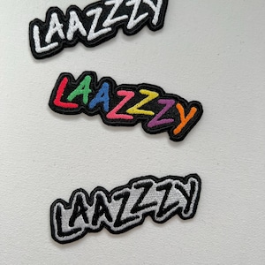 May include: Three embroidered iron-on patches with the word "LAAZZY" in different styles. The top patch has white lettering on a black background. The middle patch has rainbow lettering on a black background. The bottom patch has gray lettering on a black background.