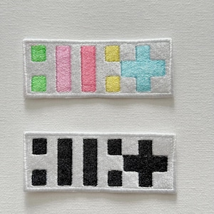 May include: Two embroidered patches, one with a colorful design of three vertical bars and a plus sign, and the other with a black and white design of three vertical bars and a plus sign.