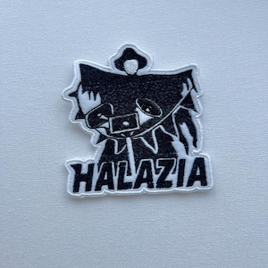 Könnte beinhalten: Schwarz-weißer, gestickter Aufnäher mit einer stilisierten Figur mit Kapuze und Lautsprechern. Das Wort "HALAZIA" ist weiß gestickt. Der Aufnäher ist wahrscheinlich für Kleidung oder Accessoires gedacht.