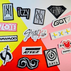 Può includere: Una collezione di 12 toppe ricamate colorate con i nomi di gruppi K-pop popolari, tra cui Stray Kids, Ateez, Day6, Momoland e altri.