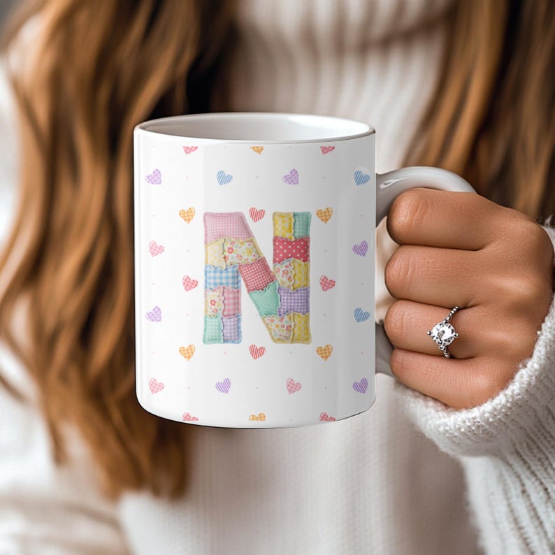 May include: A white ceramic mug with a black handle and the text "But First, Coffee" in a black, handwritten-style font. The mug is on a white surface.