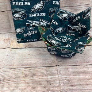 Könnte beinhalten: Ein Set aus zwei grünen und weißen Topflappen aus Stoff mit dem Logo der Philadelphia Eagles und den Worten "Philadelphia Eagles".