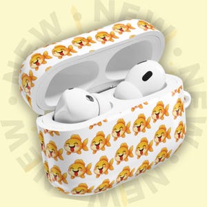 May include: White AirPods case with a repeating pattern of smiling orange goldfish. The case is open, revealing white AirPods inside. The background is a light yellow with the word "NEW" repeated.