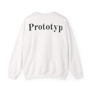 Könnte beinhalten: Ein weißes Sweatshirt mit dem Wort "Prototyp" in Schwarz auf dem oberen Rücken aufgedruckt. Das langärmlige Oberteil mit Rundhalsausschnitt ist aus einem weichen Material gefertigt.