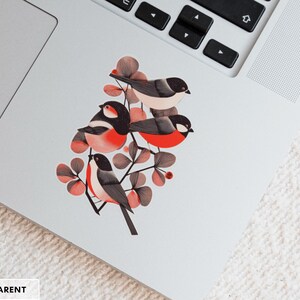 A beautiful and minimal illustration of four finches perched in a tree. Design is black, red and cream, printed on a kiss-cut vinyl sticker with a transparent border. Sticker is shown on an open silver laptop, next to the track pad.